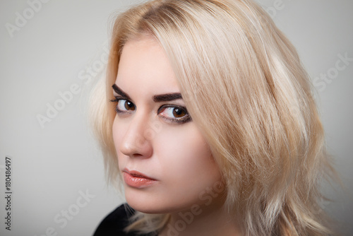 Blonde girl with bright makeup and clean skin on a white isolate close-up