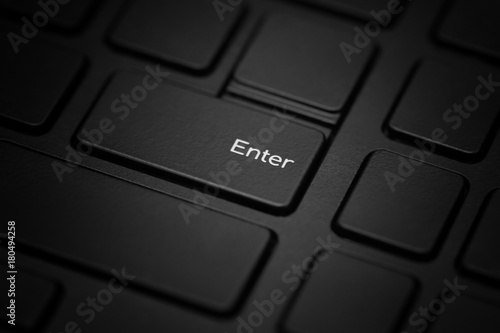 The enter key on a black laptop is close-up.