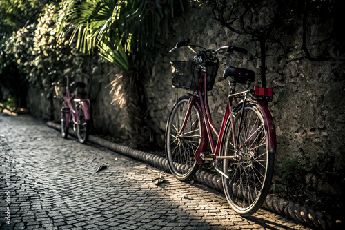 Two bicycles leaning against the wall