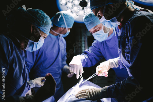 Medical team performing surgical procedure in operating theater