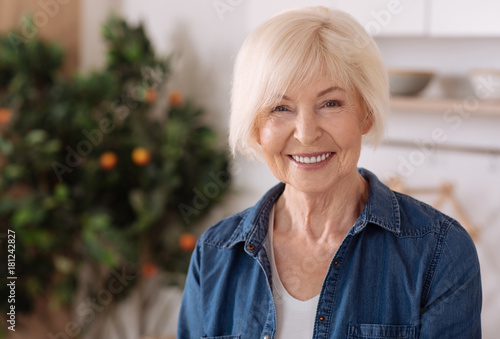 Cheerful elderly woman standing in the kitchen