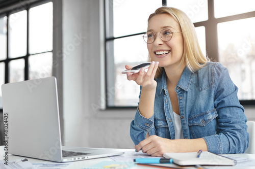 Smiling female executive officer communicates with employees, makes voice call, discuss business trip together, uses free wireless internet connection. Leader council has distant phone conversation