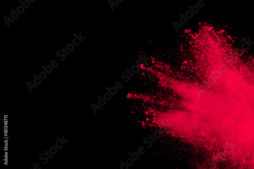 Abstract red powder explosion on black background. Freeze motion of red powder splash. red dust splattered on background.
