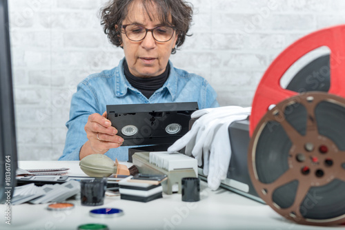 technician woman with VHS cassette for digitization