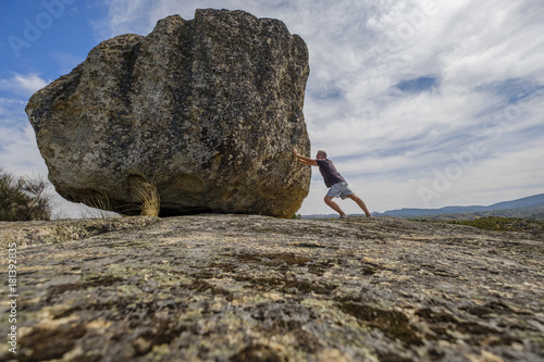 Man pushing a big stone