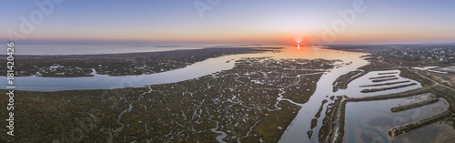 Aerial sunset seascape in Ria Formosa wetlands natural park, inland maritime channel. Algarve.