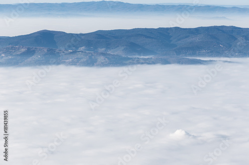 Fog filling a valley between some mountains and hills