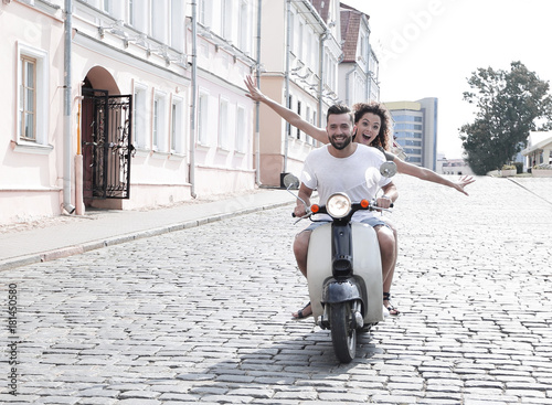 Happy young couple having fun on a scooter