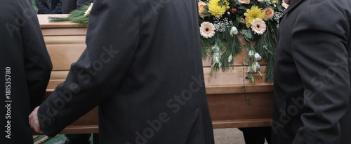 Sargträger tragen einen mit Blumen geschmückten Sarg