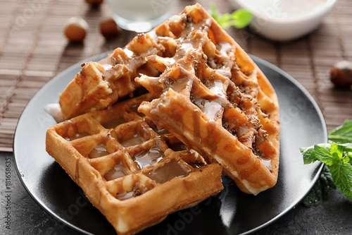 Tasty waffles and caramel topping on plate