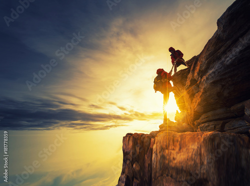 Asia couple hiking help each other silhouette in mountains with sunlight.