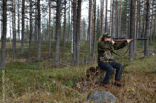 Young female moose hunter aiming