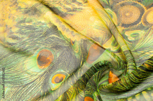 Background texture, drawing. Silk fabric. Light airy fabric. Green with peacock feathers. Yellow shade. Fabric cotton silk batiste mint green airy very light transparency