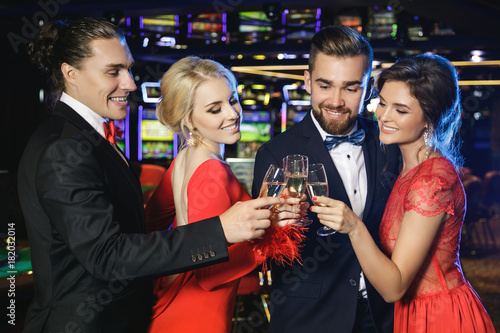 Group of happy people drinking sparkling wine in the casino