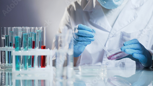 Cosmetology lab assistant preparing organic substance for anti-aging cream