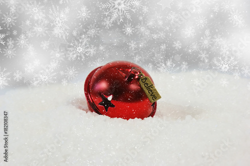 Christmas bell with believe label nestled in snow