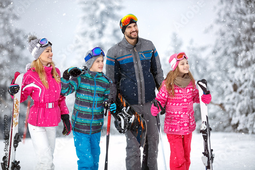 Family on winter holiday going to ski terrain