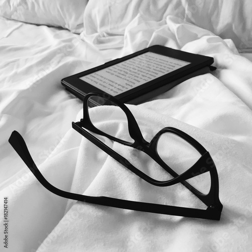 glasses and ebook on the bed