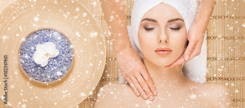 Young and healthy woman getting health care treatments in massaging salon. Winter and Christmas spa concept.