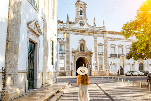 Young woman in hat in front of church, Faro, Portugal