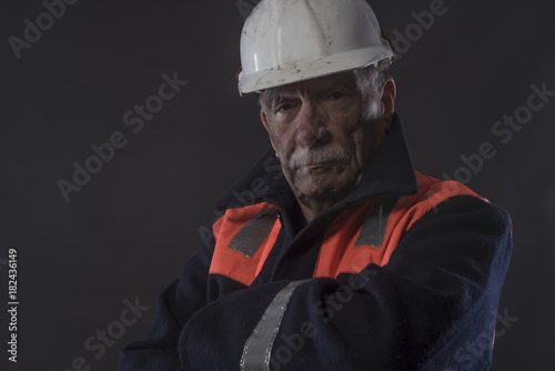 Portrait image of a mature traditional miner with his arms crossed, 