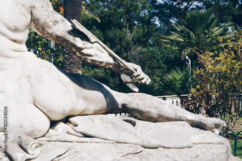 Statue of Achilles trying to remove the arrow from his hill.