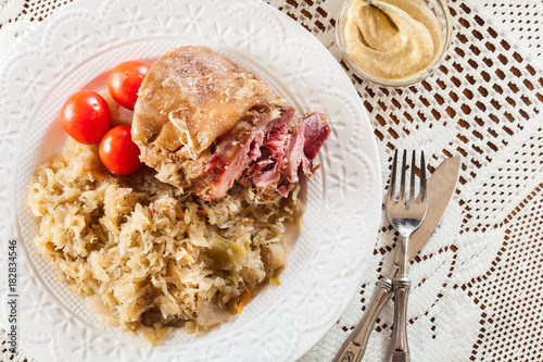 Pork knuckle with fried sauerkraut and tomatoes