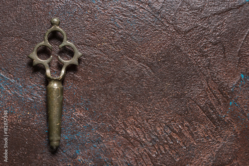 Antique brass samovar tap key on dark background, copy space