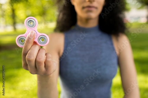 Girl holding a fidget spinner in a park