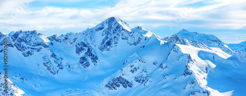 Mountains in snow. Panorama of winter landscape with peaks and blue sky