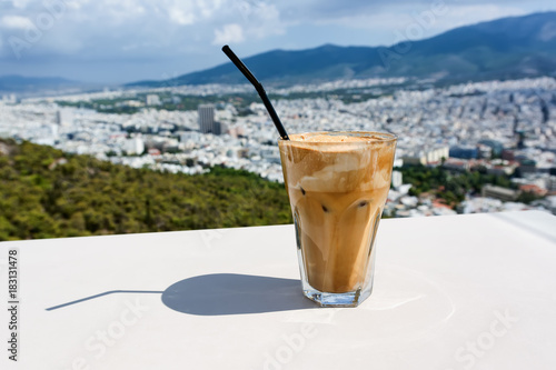 Ice frappe coffee and view of town of Athens for background.