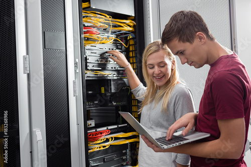 Team of technicians working together on servers at the data centre