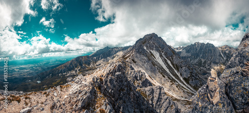 Mountain stone range peak against blue cloudy sky. Nature landscape. Travel background. Holiday, hiking, sport, recreation. National Park High Tatra, Slovakia, Europe. Vintage retro toning filter