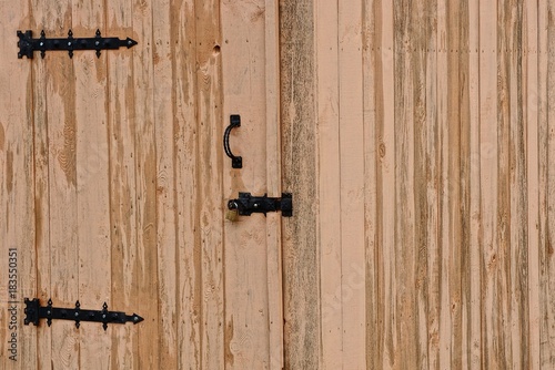 деревянная закрытая дверь на замке на деревянной стене дома 