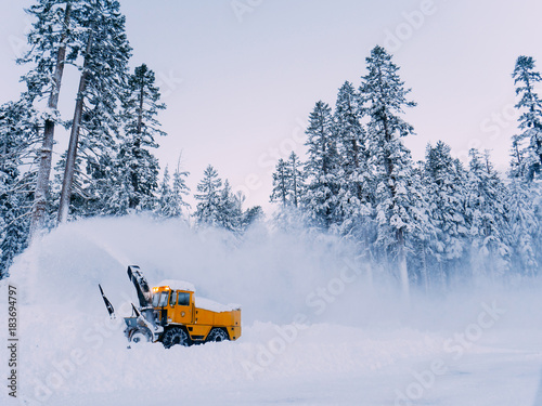 Tractor is best for snow plowing (snow removal). California winter, Mammoth ski resort. Plowing deep snow