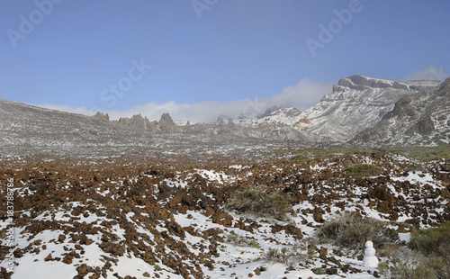 Clear day with thin, low clouds at horizon, vistas towards Llano de Ucanca, covered in snow, at the high altitude of Las Canadas del Teide, Teide National Park, Tenerife, Canary Islands, Spain
