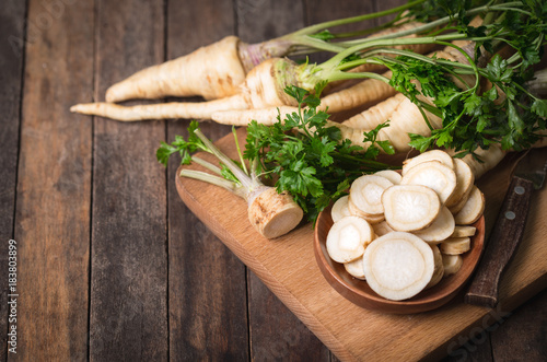 Fresh parsley root on the wooden table