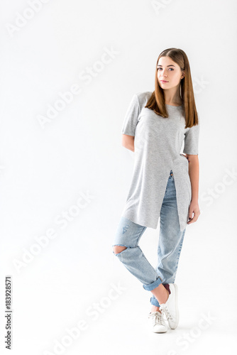 pensive young woman in stylish clothing looking at camera, isolated on white