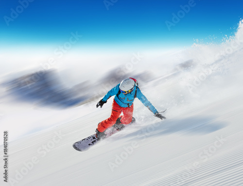 Young man snowboarder running downhill in fast motion