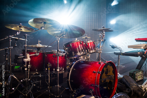 drum set on stage and light background; empty stage with instruments ready for performance