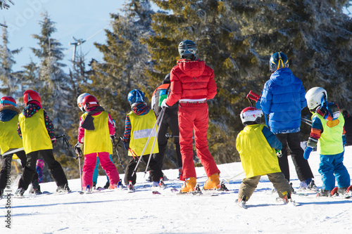 Ski instructor teaching young kids to skiing