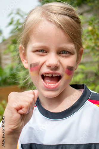 Kind im Deutschland Trikot ballt die Faust und jubelt