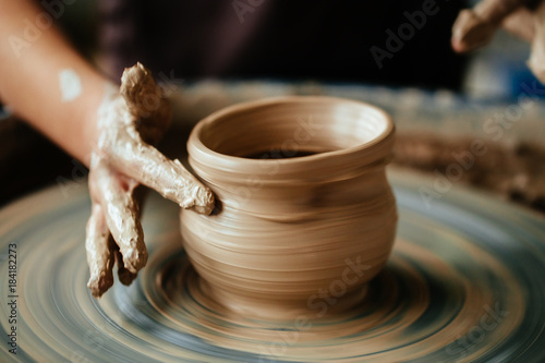 Hands of young potter, close up hands made cup on pottery wheel
