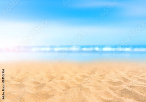 Sandy beach with blurry blue ocean