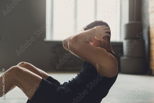 Young man fitness workout, sit-up crunches for abs