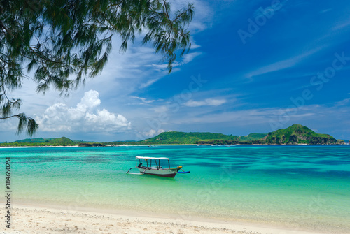tropical beach in island Lombok, Indonesia with boat and turquoise lagoon.
