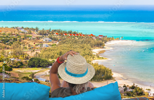 femme au chapeau contemplant Port Sud-Est et la plage de Mourouk, île Rodrigues, Maurice 