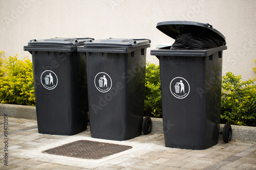 Black indoor waste containers for recycling and garbage. A lot of closed and recycle receptacles trash bin outside