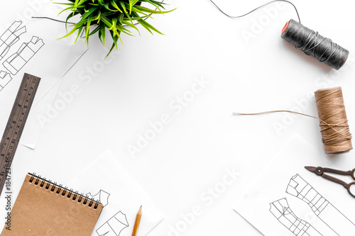 Tailor's work desk. Pattern of clothing and tools on white background top view copyspace