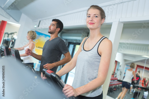 people running in machine treadmill at fitness gym